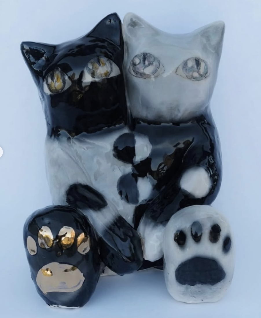 Black and white ceramic cat figure with large paws