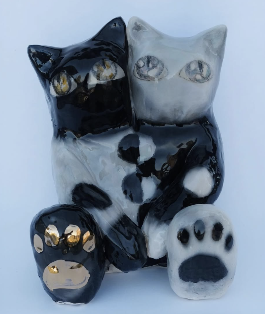 Black and white ceramic cat figure with large paws