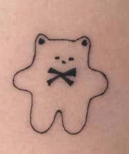 Linework tattoo of a small bear-cat with a bow mouth