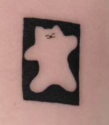 Blackwork tattoo of a small cat silhouette in a rectangle