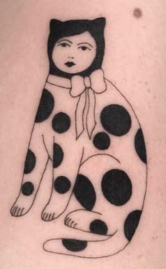 Linework tattoo of a spotted cat with a human face and bow