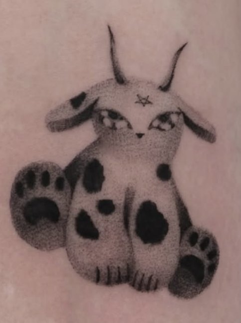Stippled tattoo of a horned spotted creature