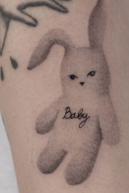 Stippled tattoo of a plush bunny labelled Baby
