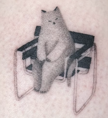 Soft shaded tattoo of a cat sitting in a chair