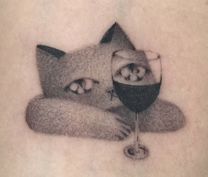 Shaded tattoo of a cat resting behind a wine glass