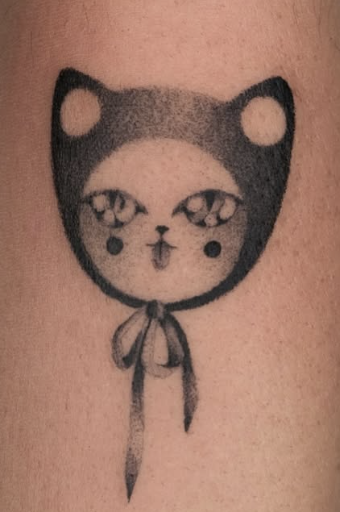 Shaded tattoo of a small hooded face with sparkling eyes